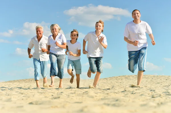 Retrato de una familia feliz un pie descalzo corriendo — Foto de Stock