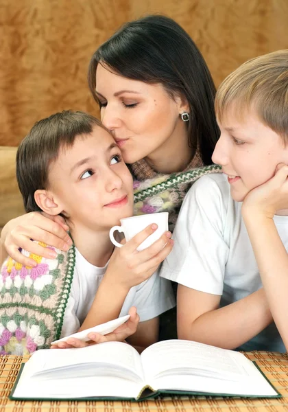 Schöne gute kaukasische Mutter mit ihrem Sohn, der ein Buch liest — Stockfoto