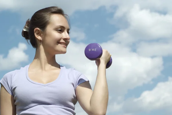 Girl with dumbbell outdoors — Stock Photo, Image