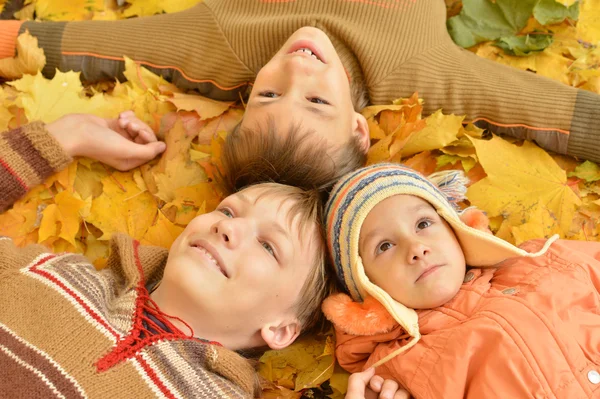 一家三口躺在黄色的树叶上 — 图库照片