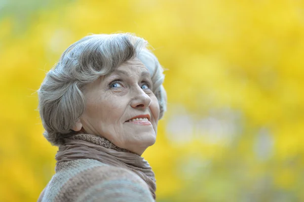 Thoughtful senior woman in autumn — Stock Photo, Image