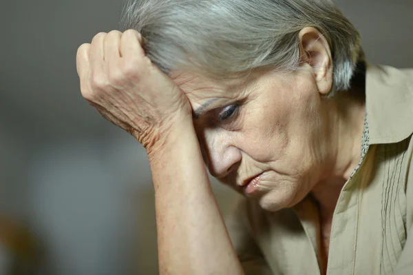 Triste donna anziana su sfondo grigio — Foto Stock