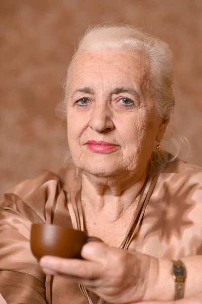 Старшая женщина с чашкой — стоковое фото
