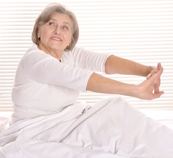 Mujer mayor descansando en el dormitorio — Foto de Stock