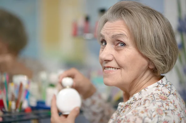 Senior woman applying cream — Stock Photo, Image