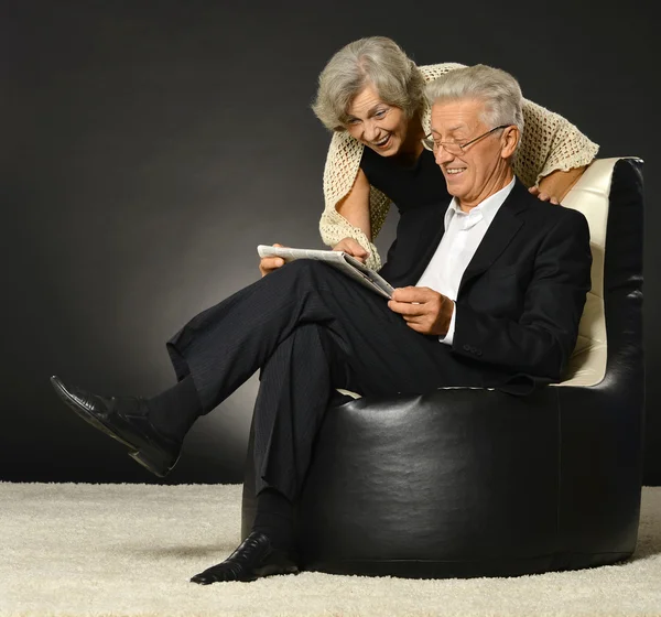 Пожилая пара читает газету — стоковое фото