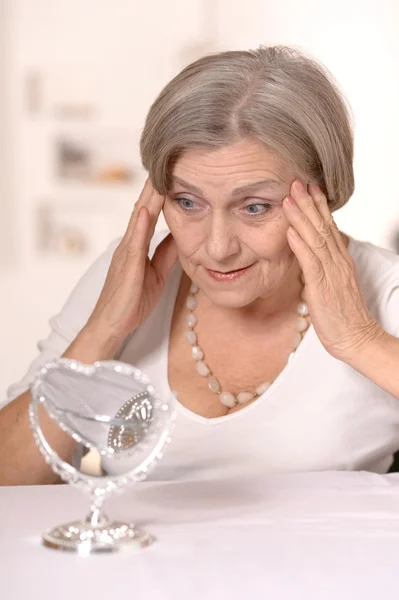 Senior woman doing makeup — Stock Photo, Image