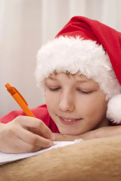 Chłopiec w santa hat pisania — Zdjęcie stockowe