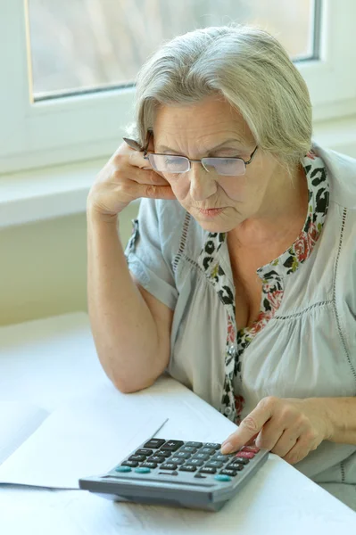 Ernstige oudere vrouw met calculator — Stockfoto