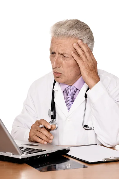 Medico anziano con un computer portatile — Foto Stock