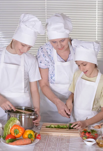 Happy grandmother and her grandchildren cook together — Stock Photo, Image