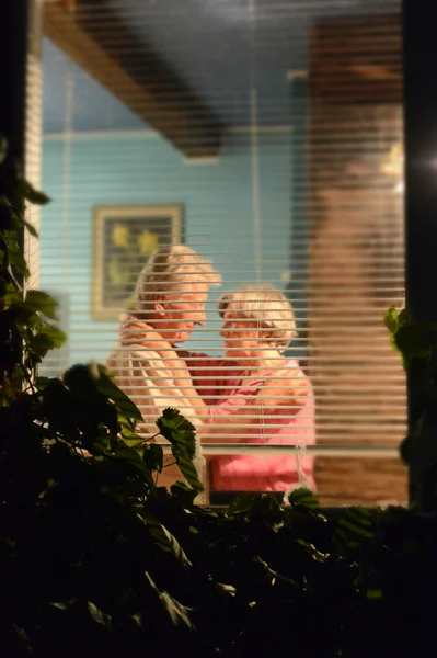 Feliz pareja de ancianos en la casa, foto hecha fuera de la casa —  Fotos de Stock