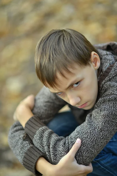 Портрет грустного мальчика на улице осенью — стоковое фото