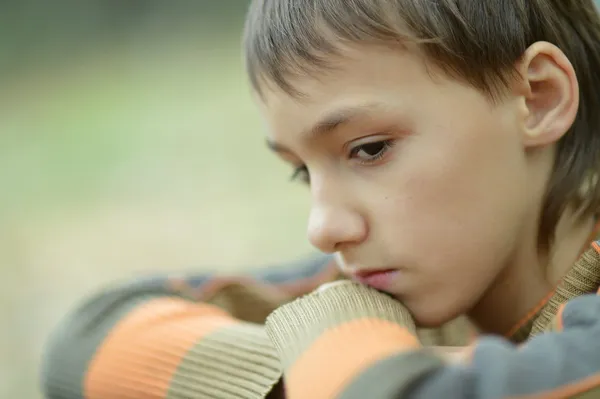 Портрет грустного мальчика на улице осенью — стоковое фото