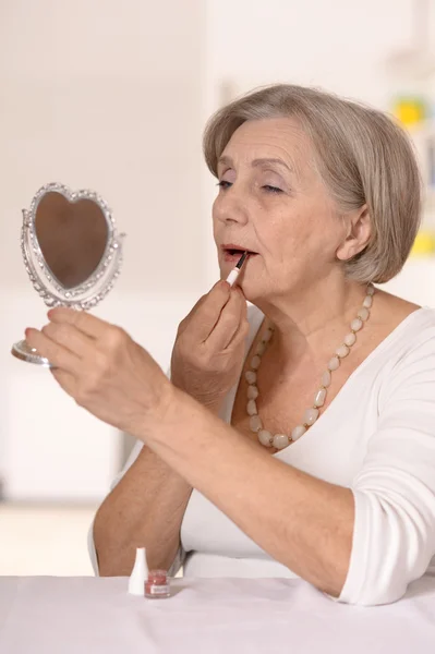 Старша жінка робить макіяж у ванній — стокове фото