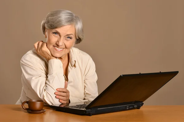 Oude vrouw met een laptop — Stockfoto