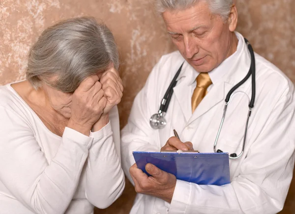 Triste mujer mayor con médico — Foto de Stock