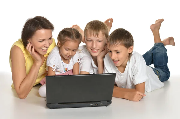Famiglia sdraiata su un piano con computer portatile — Foto Stock