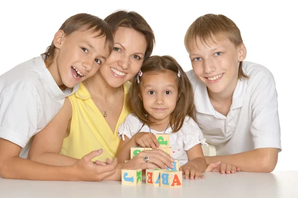 Madre y sus hijos jugando con cubos aislados en blanco — Foto de Stock