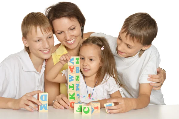 Mãe e seus filhos brincando com cubos isolados em branco — Fotografia de Stock