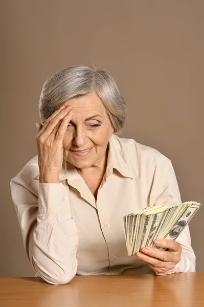 Aged woman holding dollars — Stock Photo, Image