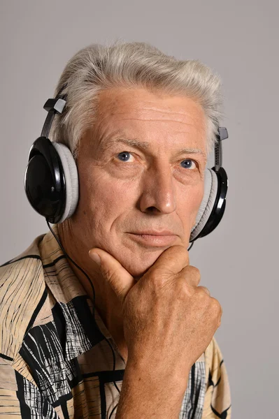 Elderly man listen to music in headphones — Stock Photo, Image