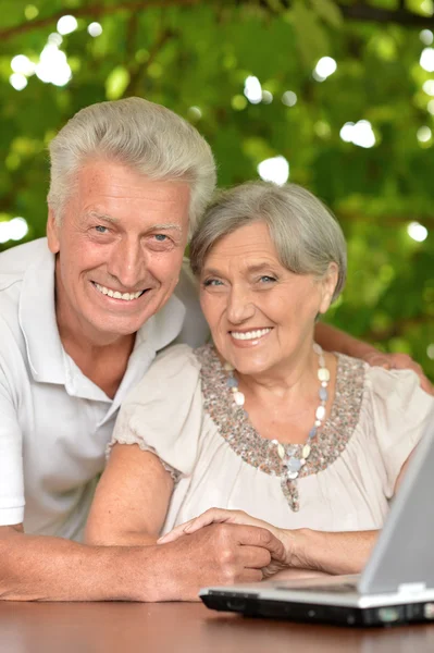 Elderly couple sitting at table — Stock Photo, Image