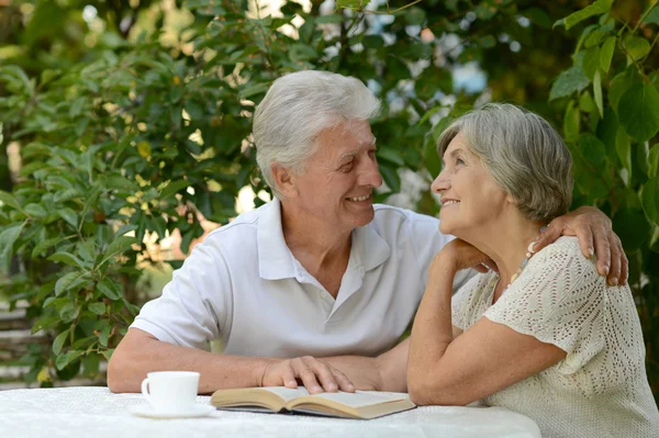 Elderly couple sitting at table — Stock Photo, Image