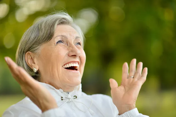 Porträtt av glad äldre kvinna i park — Stockfoto