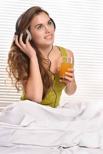 Девушка пьет сок в постели — стоковое фото