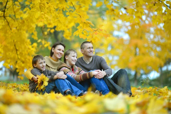 Happy family lying in autumn park — Stock Photo, Image