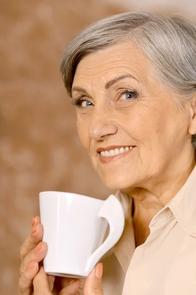 Aged woman drinking coffee — Stock Photo, Image