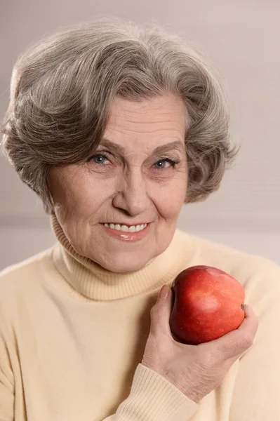 Hermosa anciana con una manzana — Foto de Stock