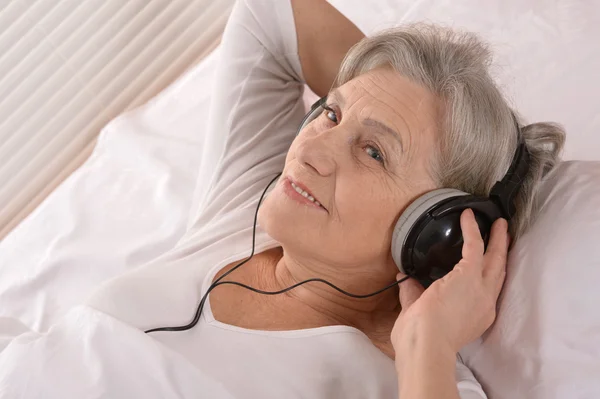 Senior senhora em fones de ouvido — Fotografia de Stock