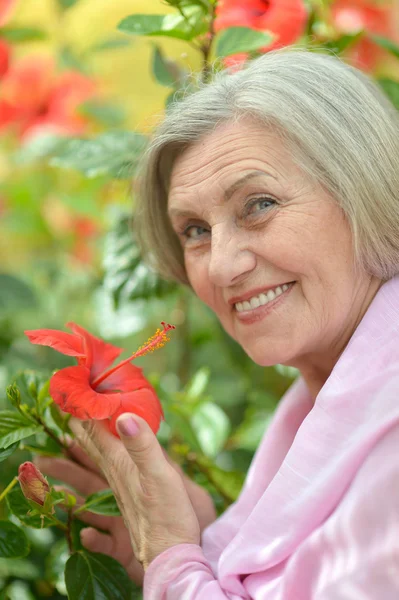 Older woman with flowers — Stock Photo, Image