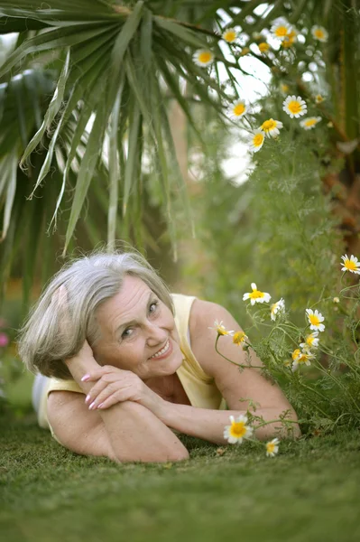 Elderly woman lying at resort — Stock Photo, Image