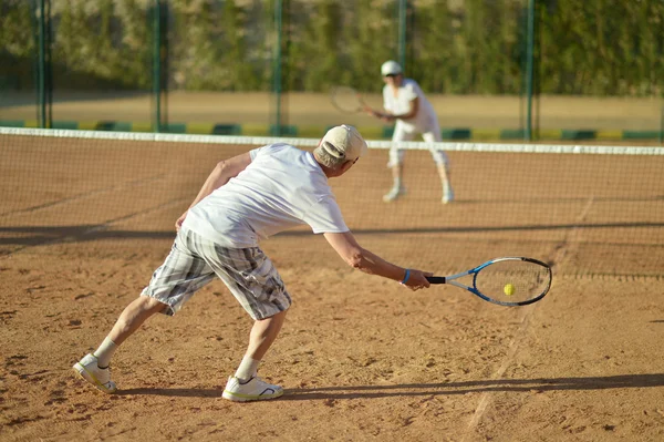 Couple senior jouant au tennis — Photo