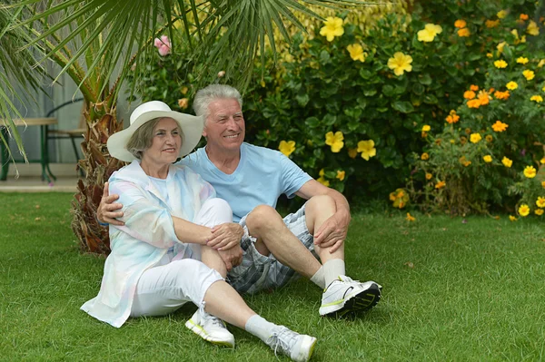 Pareja mayor sentada en el jardín del hotel tropical —  Fotos de Stock