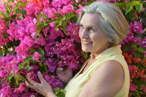 Mujer mayor con flores — Foto de Stock