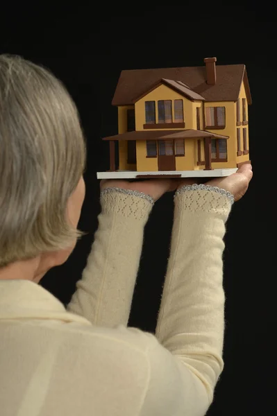 Old Woman holding miniature house — Stock Photo, Image