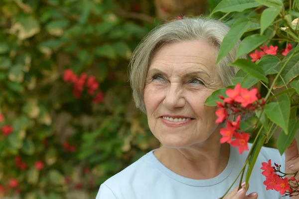 Older woman with flowers — Stock Photo, Image