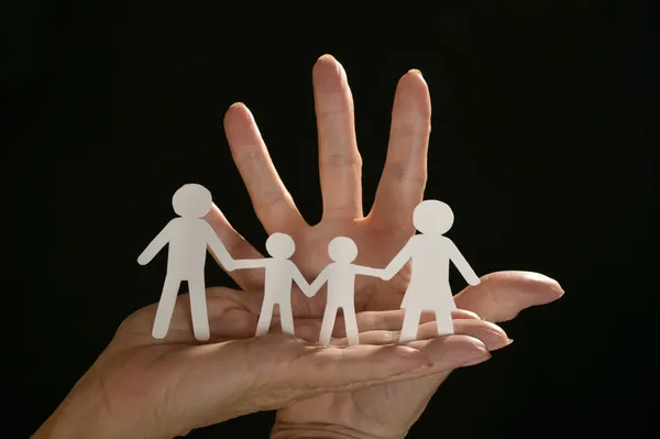 Ręce, trzymając papier rodziny — Zdjęcie stockowe