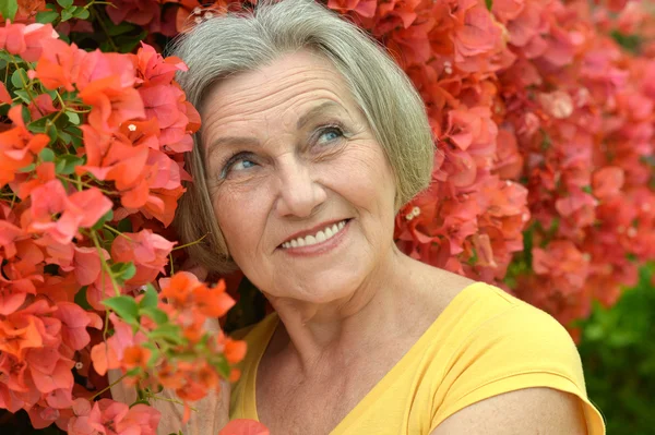 Older woman with flowers — Stock Photo, Image