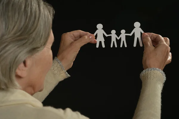 Старшая женщина держит бумажную семью — стоковое фото