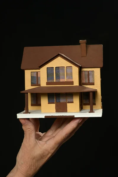 Miniaturowe domu trzymając się za ręce kobiety — Zdjęcie stockowe
