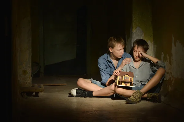 Two lonely little boys   in a dark cellar — Stock Photo, Image