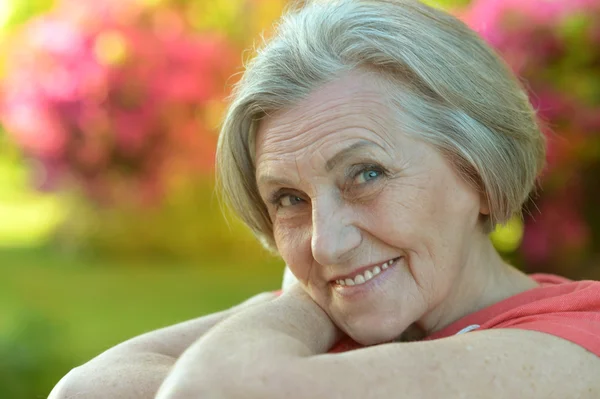 Older woman with flowers — Stock Photo, Image