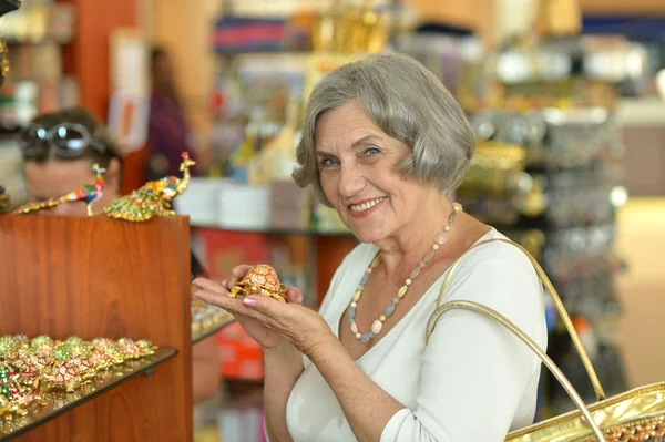 Senior vrouw bij souvenir winkel — Stockfoto