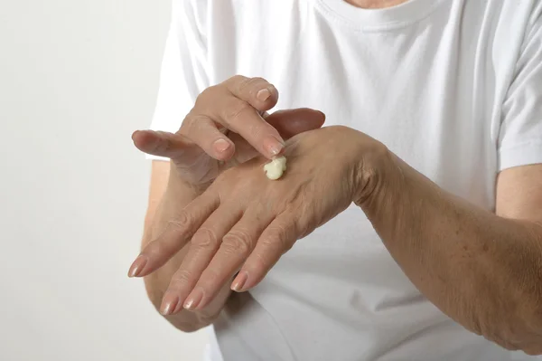 Woman applying cream on hands — Stock Photo, Image