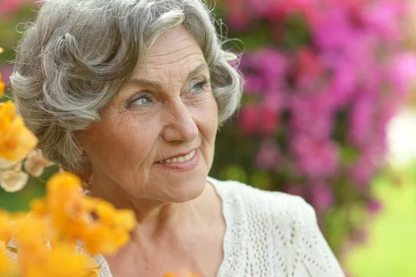 Eldre kvinne med blomster – stockfoto